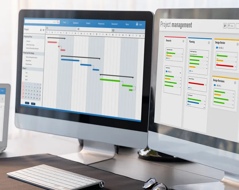 Project management software on computer screens.